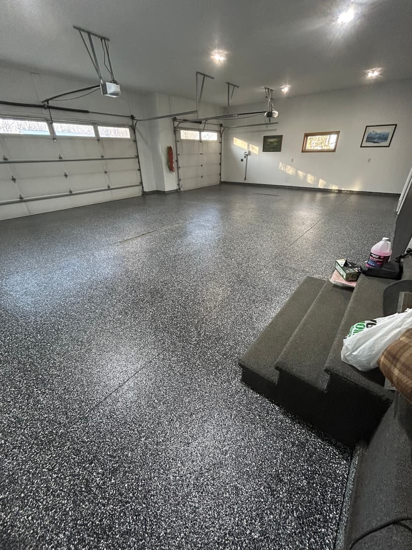 Spacious, clean garage with a polished floor, natural light, and organized storage options.